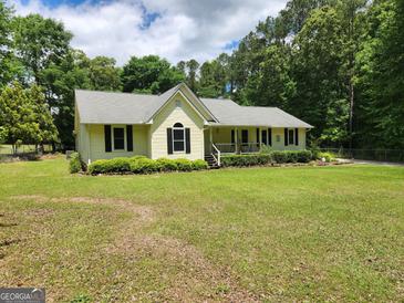 Charming single-story home with a well-manicured lawn and mature landscaping at 350 Lakeview Dr, Brooks, GA 30205
