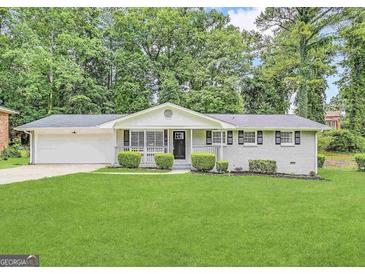 Charming single-story home with a well-manicured lawn, painted brick, and a cozy front porch at 4487 Greenleaf Sw Cir, Atlanta, GA 30331