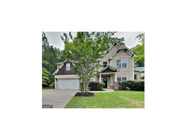 Inviting home featuring a lush green lawn, mature trees, and a two-car garage at 330 Bentleigh Station Dr, Acworth, GA 30101