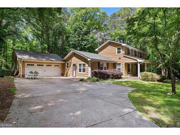 Inviting two-story home with a spacious driveway and attached two-car garage, set amidst lush greenery at 2201 Valley Creek Cir, Snellville, GA 30078