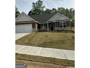Charming single-story home boasting a manicured lawn, stone accents, and a convenient attached two-car garage at 3006 Fairway Dr, Villa Rica, GA 30180