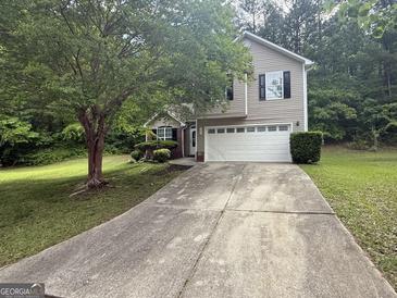 Charming two-story home with a two-car garage and well-maintained lawn at 7090 E Village Ct, Riverdale, GA 30296