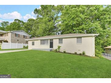 Charming single-story home with lush green lawn and mature trees, providing great curb appeal at 6309 Wellington Way, Austell, GA 30106