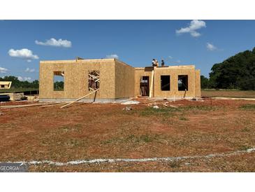 New home is under construction with wood framing and a blue sky on a large lot at 1916 King Mill Rd, Mcdonough, GA 30252