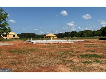 New home construction site with concrete foundation and wood framing under a blue sky at 1936 King Mill Rd, Mcdonough, GA 30252