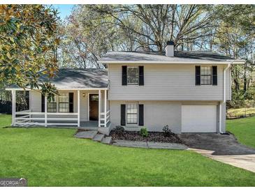 Charming split-level home featuring a front porch, well-maintained lawn, and attached garage at 3879 Mcgill Ln, Decatur, GA 30034