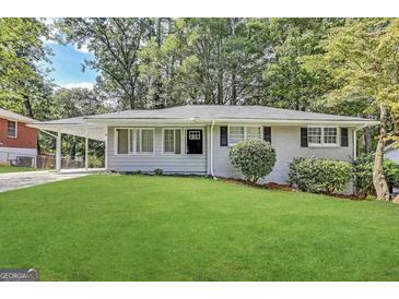 Charming home boasts a well-manicured lawn and inviting curb appeal with a side carport at 2651 Lois Se Ln, Atlanta, GA 30315