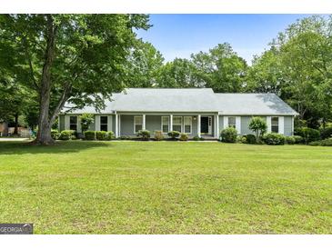 Charming single-story home with lush green lawn, mature trees and gray shutters at 41 Ridgewood Cir, Mcdonough, GA 30252