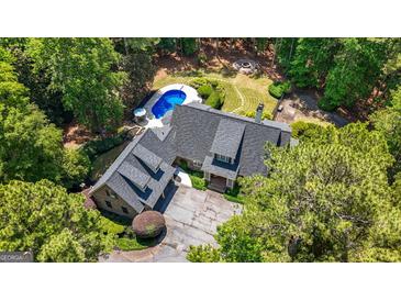 Stunning aerial view of a well-maintained home featuring a swimming pool, hot tub, and backyard fire pit at 130 Allie Drive, Mcdonough, GA 30252