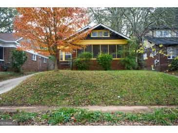 Charming brick home with a inviting screened porch and a lovely fall-colored tree in the front yard at 1660 Rogers Sw Ave, Atlanta, GA 30310