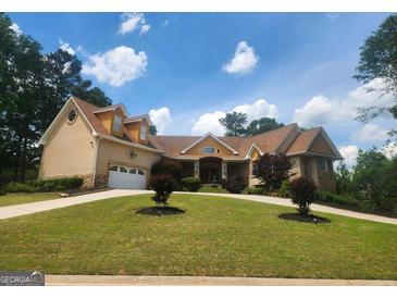 Charming exterior elevation with a well-maintained lawn and attached garage at 601 Sawgrass Walk, Mcdonough, GA 30253