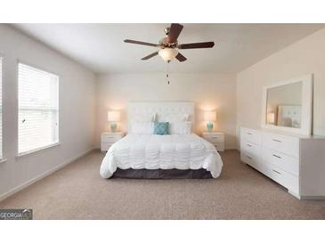 A bright main bedroom features a ceiling fan, carpeted floor and white furnishings at 2358 Argento Cir, Dacula, GA 30019