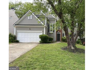 Exterior view showcasing a two-story home with attached garage, lush landscaping, and mature tree at 3838 Kirkwood Nw Run, Kennesaw, GA 30144