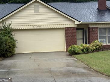 Charming single-story home featuring a brick facade, attached garage, and well-maintained front yard at 6190 Douglas Manor Ct, Douglasville, GA 30134