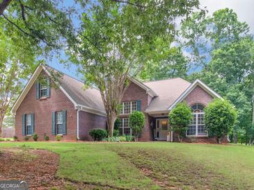 Charming brick home featuring a lush green lawn and mature trees, showcasing classic Southern architecture at 1585 Lake Dow Rd, Mcdonough, GA 30252