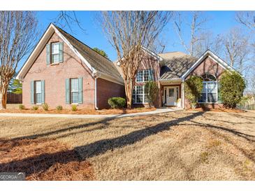 Charming brick home with a well-manicured front lawn and beautiful landscaping at 1585 Lake Dow Rd, Mcdonough, GA 30252