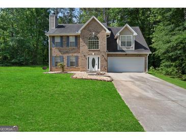 Two-story brick home featuring blue shutters, attached two-car garage and well-maintained lawn at 96 Ashtonbrook Dr, Mcdonough, GA 30252