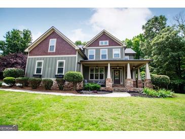 Charming two-story home featuring a welcoming front porch, beautifully landscaped lawn, and traditional architectural details at 125 High Bluff Trl, Carrollton, GA 30116