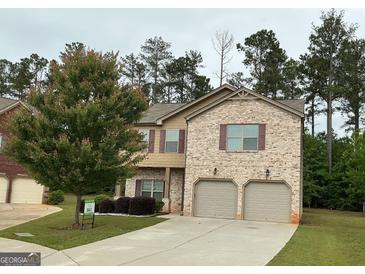 Two-story home with a two-car garage, manicured lawn, and a combination of brick and siding exterior at 620 Sedona Loop, Hampton, GA 30228
