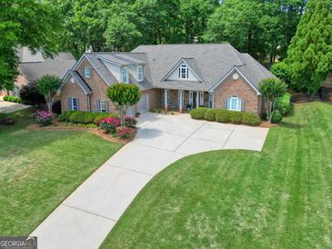Beautiful brick home with a well-manicured lawn and a long driveway at 211 English Oaks Ln, Mcdonough, GA 30253