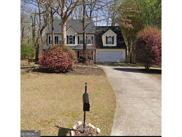 Charming two-story home with a manicured front lawn and an attached two-car garage at 6520 Glen Pond Trce, Cumming, GA 30028
