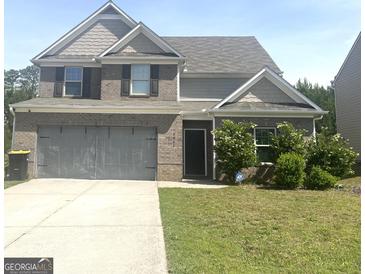 Charming two-story home with a gray brick facade, well-maintained lawn, and an attached two-car garage at 2282 Joplin St, Jonesboro, GA 30236