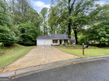 Charming single-story home featuring a two-car garage and a well-maintained front yard at 6026 Woodcreek Dr, Woodstock, GA 30188