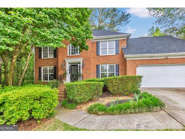 Charming two-story brick home with a well-manicured lawn and lush landscaping at 4250 Edgewater Nw Ct, Kennesaw, GA 30144