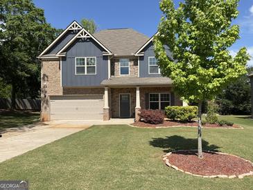 Beautiful two-story home with brick and siding, manicured lawn, and attached two-car garage at 101 Elkins Blvd, Locust Grove, GA 30248