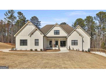 Stunning new construction home with white painted brick, black trim, and a beautifully landscaped front yard at 135 Wet Wood Dr # 12, Fairburn, GA 30213