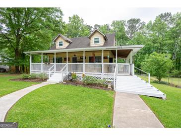 Charming home featuring a large covered porch, lush lawn, and mature trees at 3777 Edward Rd, Rex, GA 30273