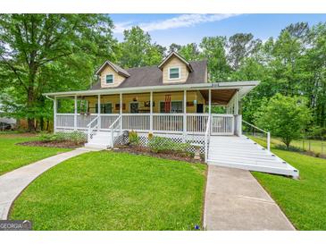 Charming two-story home featuring a welcoming front porch with white railings and a well-manicured lawn at 3777 Edward Rd, Rex, GA 30273