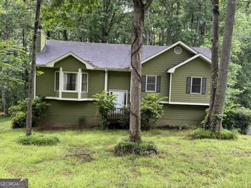 Charming green home featuring a well-maintained yard and a welcoming white front door at 133 Deerfield Ln, Carrollton, GA 30116