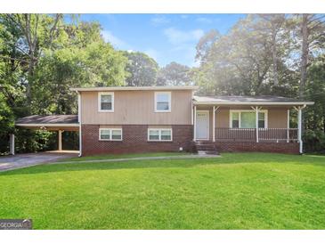 Charming two-story home with a spacious front yard and brick accents, complemented by a convenient covered carport at 115 Fairview Way, Stockbridge, GA 30281