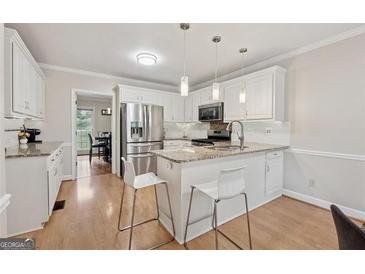 Bright kitchen features granite countertops, stainless appliances, and a breakfast bar with seating at 2622 Murdock, Marietta, GA 30062