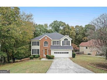 Charming two-story home featuring a brick facade and attached two-car garage at 5523 Forest Dr, Loganville, GA 30052
