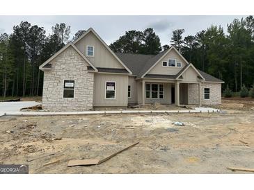 Charming single-Gathering home featuring a mix of stone and board and batten siding with a covered entryway and a gray shingle roof at 49 Durham Estates Dr, Sharpsburg, GA 30277