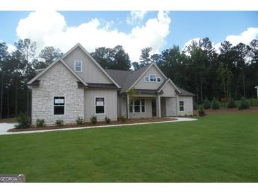 Beautiful single-story home featuring a well-manicured lawn, stone accents, and a welcoming front porch at 49 Durham Estates Dr, Sharpsburg, GA 30277