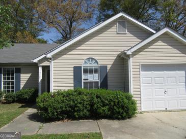 Inviting single-story home with light siding, dark shutters, and a well-maintained front yard at 5799 Eagles Feather Ln, Riverdale, GA 30274