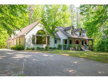 Beautiful two-story home with lush landscaping, mature trees, and a welcoming front porch at 465 Willowbrook Dr, Smyrna, GA 30082