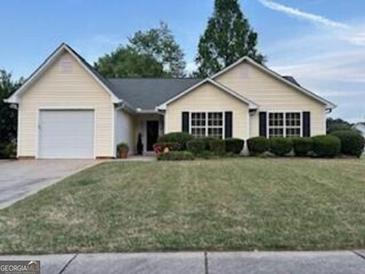 Charming one-story home with a well-manicured lawn and attached garage at 486 Village Cir, Stockbridge, GA 30281