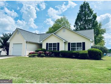 Charming one-story home with a well-manicured lawn and vibrant landscaping at 486 Village Cir, Stockbridge, GA 30281