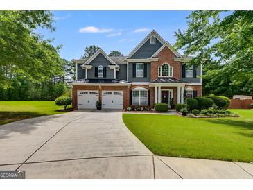 Beautiful two-story home with a well-manicured lawn, two-car garage and a brick and siding exterior at 7115 Secret Rose, Douglasville, GA 30134