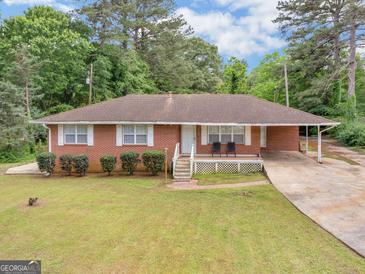 Charming single story brick home with well-manicured lawn and attached carport at 2609 Lake Harbin Rd, Morrow, GA 30260