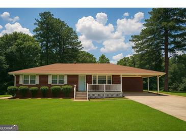 Charming brick home features a well-manicured lawn and covered front porch at 2609 Lake Harbin Rd, Morrow, GA 30260