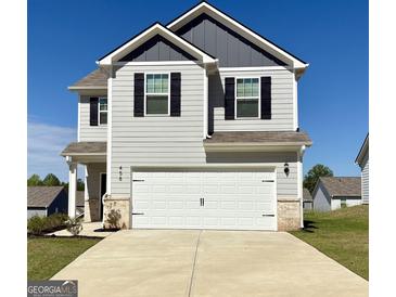 Charming two-story home featuring a two-car garage, gray siding, black shutters and well-manicured lawn at 458 Prescott Way, Villa Rica, GA 30180