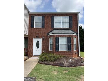Charming brick townhome featuring black shutters, a bay window, and a well-manicured front lawn at 2700 Marlin Dr, Mcdonough, GA 30253