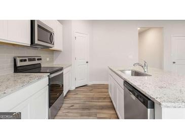 Modern kitchen featuring stainless steel appliances, granite countertops and white cabinets at 7222 Lacey Dr. # 127, Douglasville, GA 30134