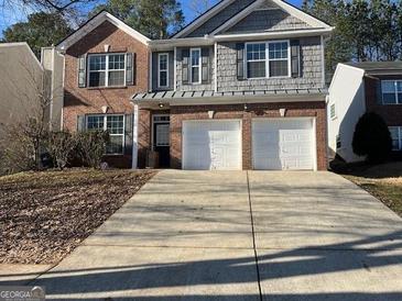 Charming two-story home with a brick and gray shingle exterior and a spacious two-car garage at 1870 Wildcat Trace Cir, Lawrenceville, GA 30043