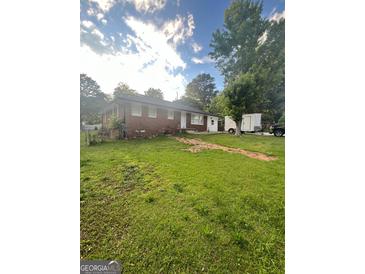 Charming single-story brick home with a spacious front yard and mature trees at 4111 Scott Dr, Forest Park, GA 30297